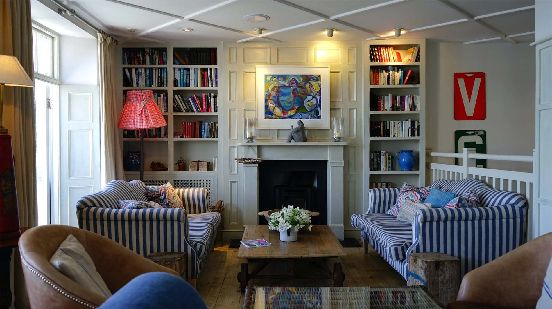 LED lighting pointing towards artwork over fireplace and bookcase