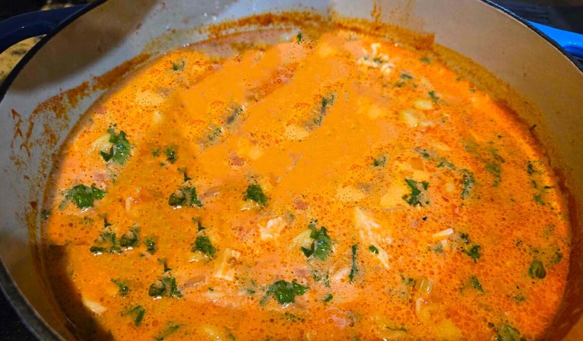 Chicken Tortellini Soup in a pot on a stove.