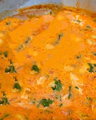 Chicken Tortellini Soup in a pot on a stove.