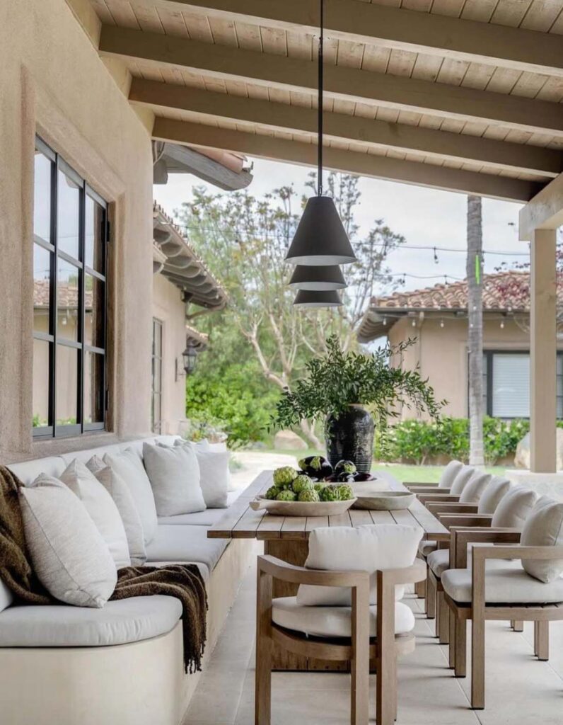 Patio with long table bench and chairs.