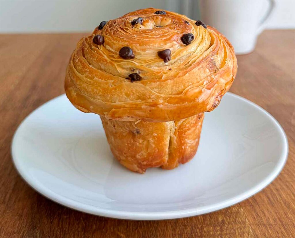 chocolate chip sourdough cruffin on a white plate