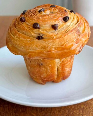 chocolate chip sourdough cruffin on a white plate