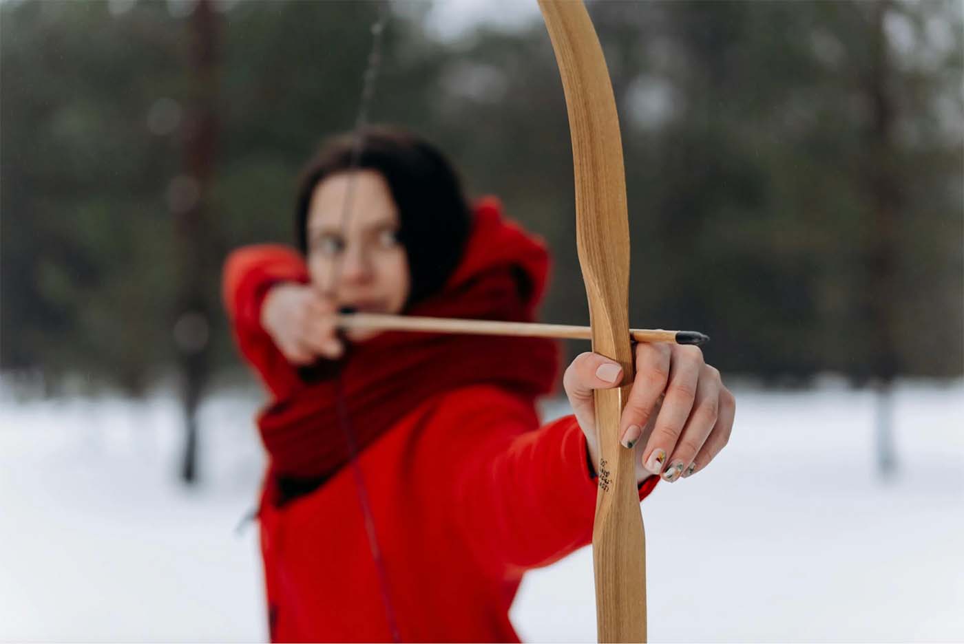 Woman using wooden bow.