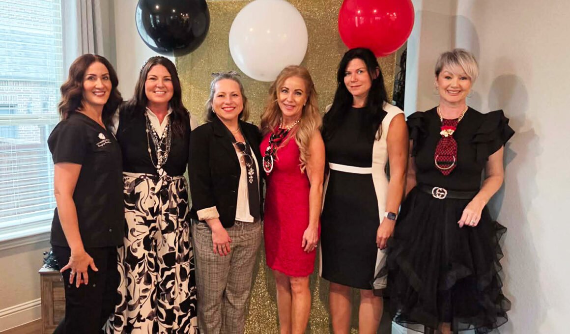 Corinna Slamons, co-hosts, and Women In Need representatives posing together at a “Devil Wears Prada” themed charity event in North Texas