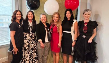 Corinna Slamons, co-hosts, and Women In Need representatives posing together at a “Devil Wears Prada” themed charity event in North Texas