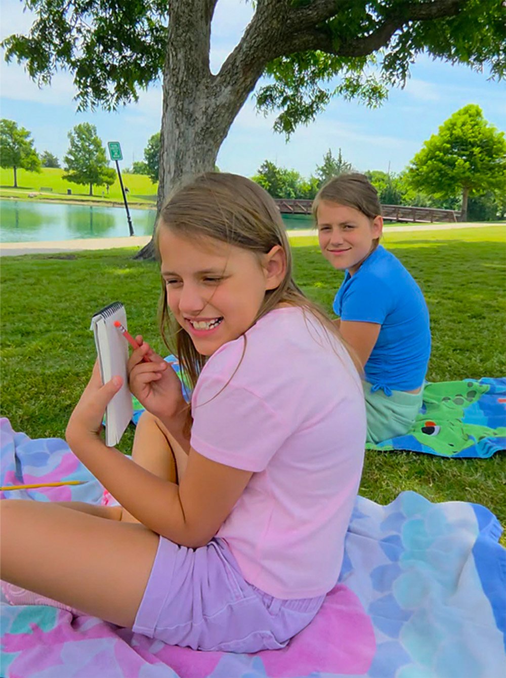 Children participating in plein air sketching beneath a tree at Harry Myers Park in Rockwall Texas