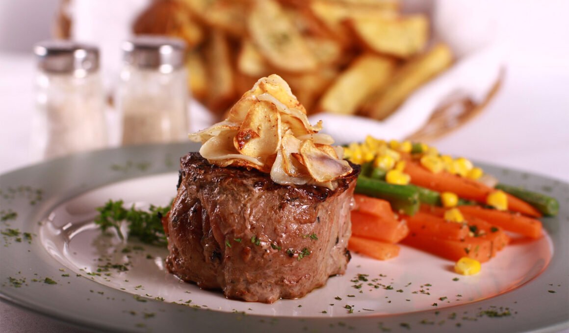 Gourmet steak, vegetables and fries.