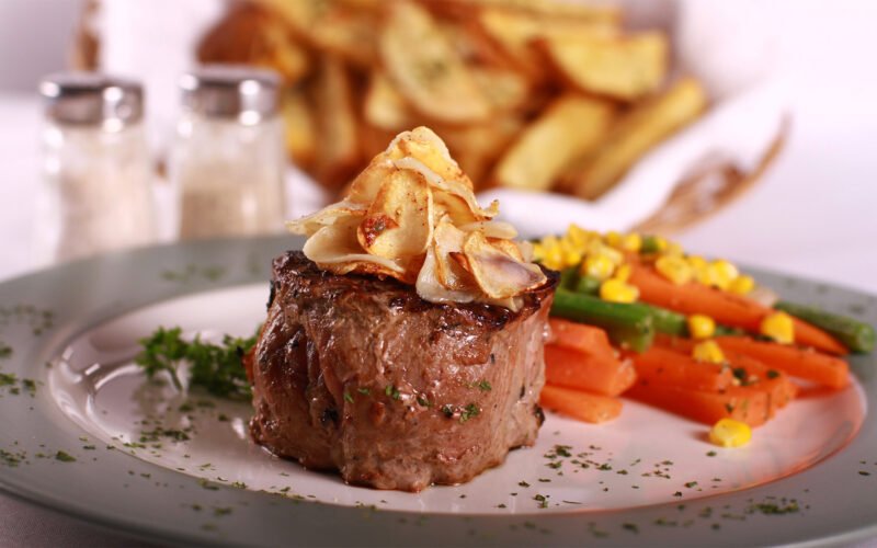 Gourmet steak, vegetables and fries.