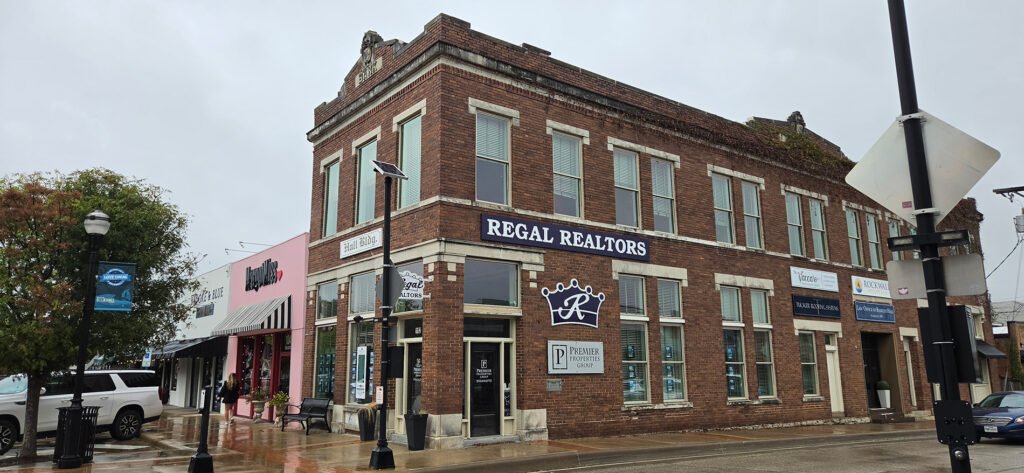 The former bank building at San Jacinto and Rusk continues its commercial life in 2026, now occupied by real estate, roofing and other professional-service businesses.